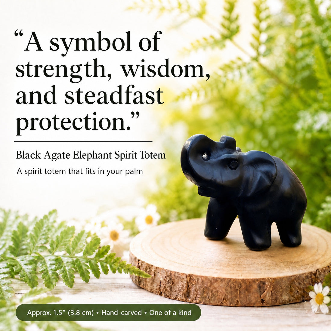 A carved black agate elephant with its trunk raised, standing on a wooden slice among ferns and daisies