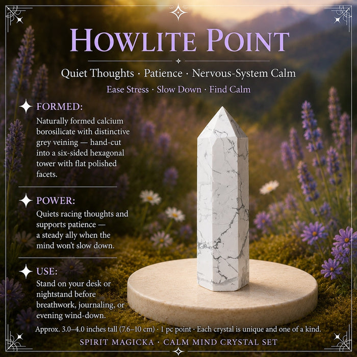A white howlite point with grey veining standing on a stone disc among lavender