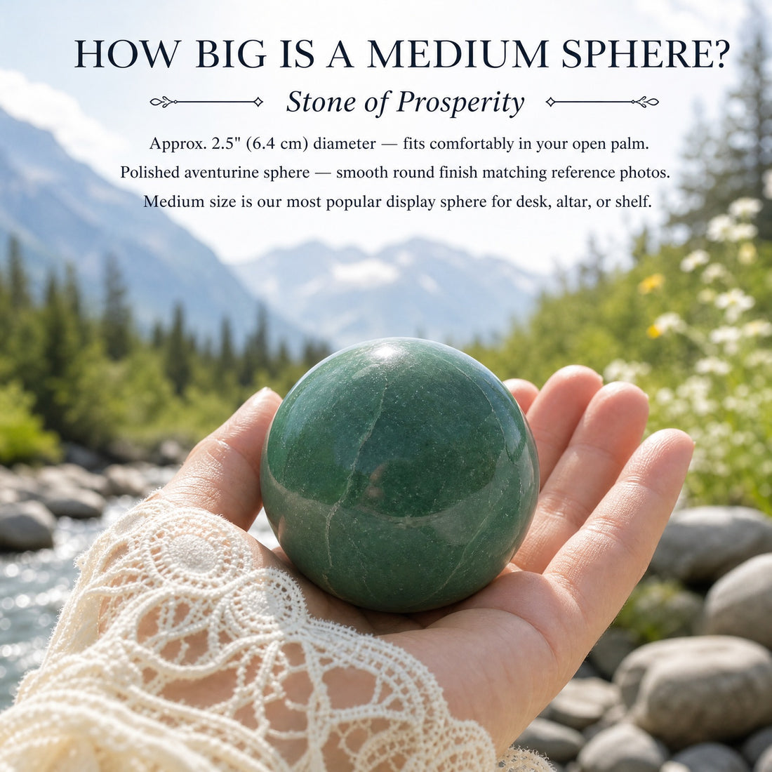 A medium green aventurine sphere resting in an open palm beside a mountain stream