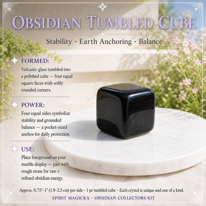 Polished obsidian tumbled cube with softly rounded corners on a white marble platter