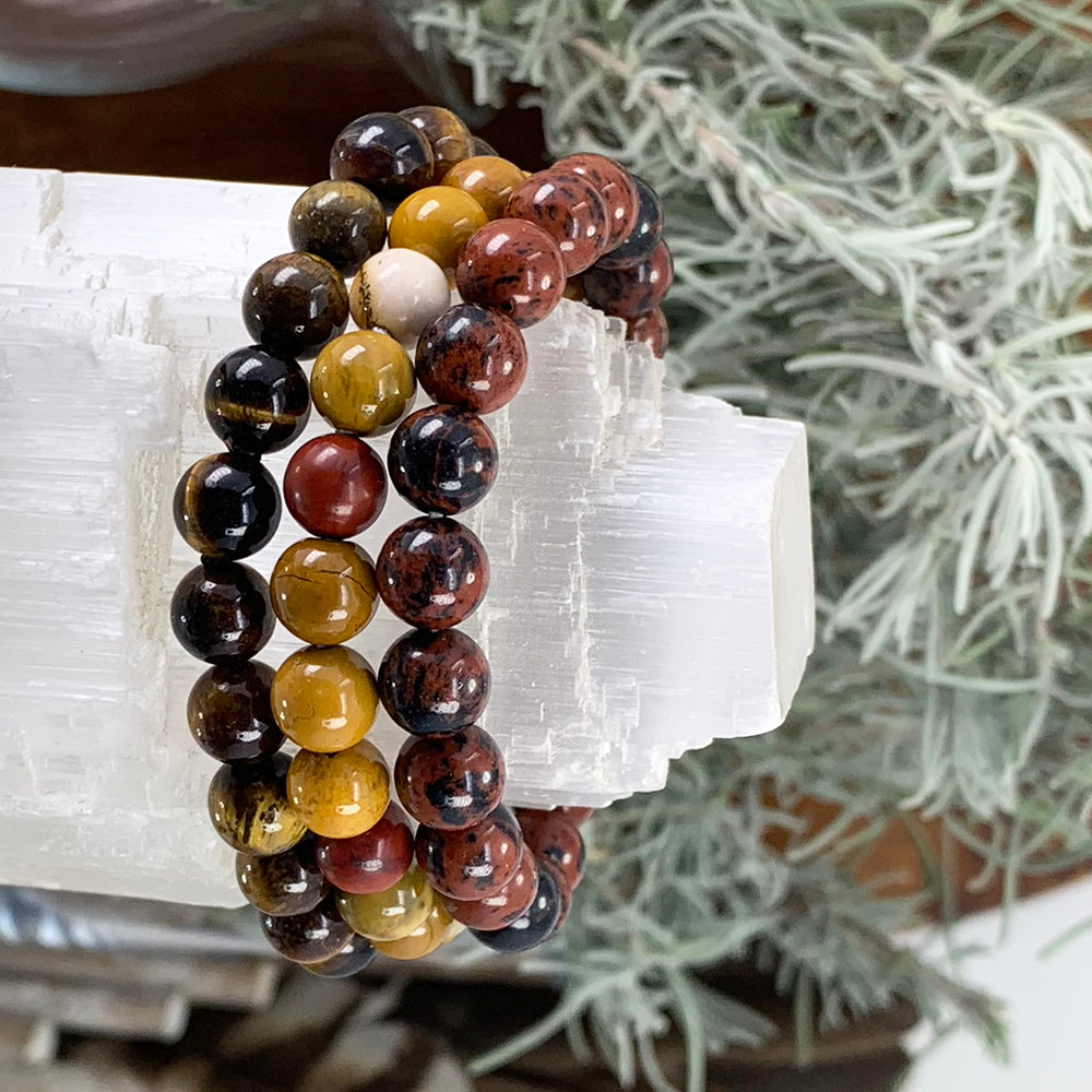 Tiger’s eye, golden mookaite and red obsidian bead bracelets stacked on a selenite tower