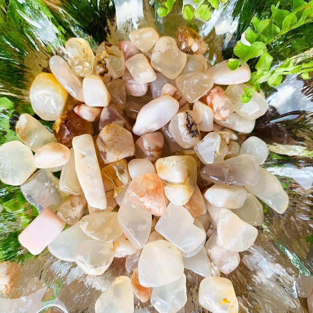 Close view of cherry flower agate mini gemstones in white, pink and peach with black and yellow inclusions