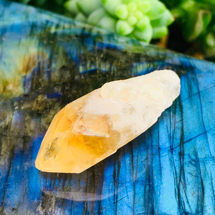 A golden citrine shard on a labradorite slab