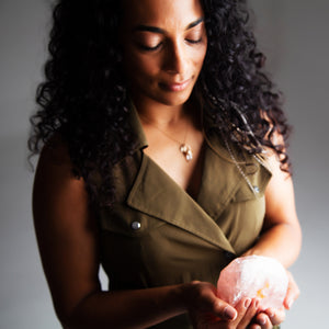 Shanti Faiia holding a glowing rose quartz sphere in both hands