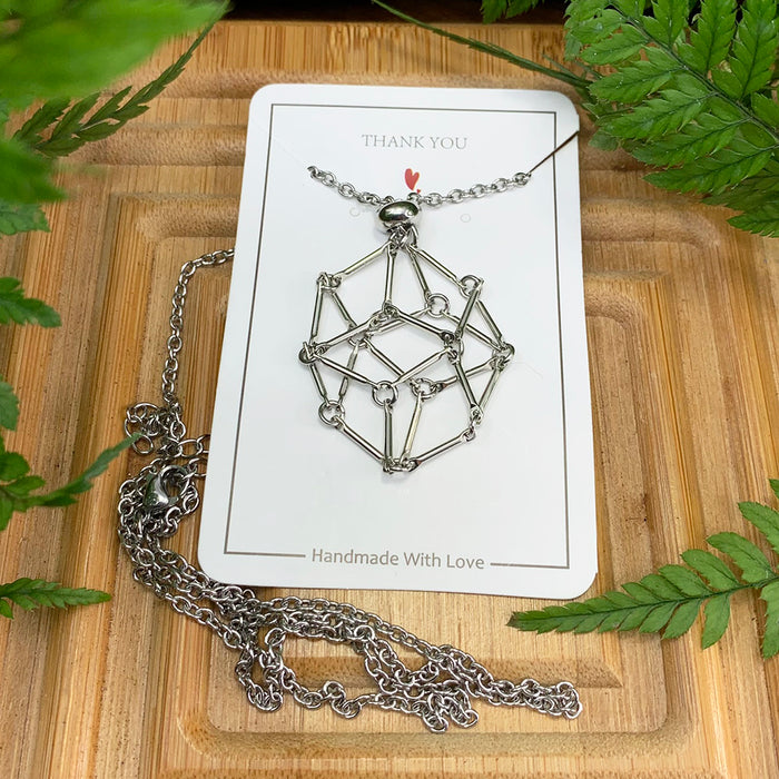 The silver-tone chain-basket necklace on its card with the chain laid out