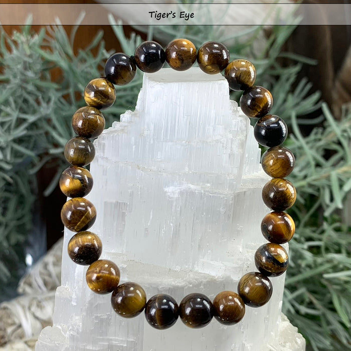 Golden-brown tiger's eye bead bracelet on a selenite tower